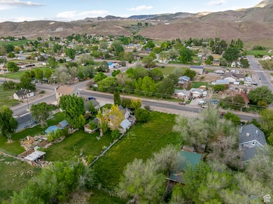 Aerial view of property and surrounding area with nearby suburban area and mountains