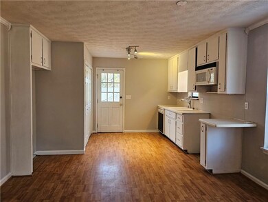 Kitchen with white cabinets, light countertops, di