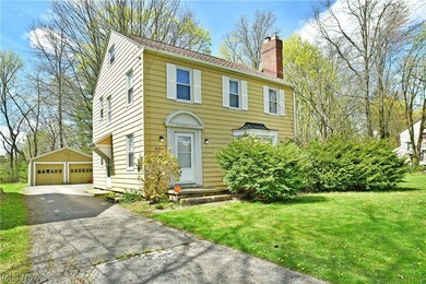 View of front facade featuring a garage, a front lawn, and an outdoor structure