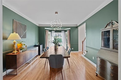 Dining space featuring a chandelier, baseboards, w