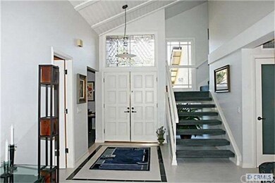 Double door entry opens to custom tiled foyer and 