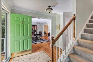 Foyer features wood floors, crown moulding, chairr