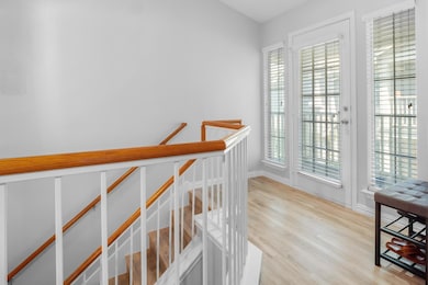 Hall featuring an upstairs landing, wood finished
