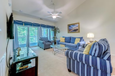 Carpeted living room featuring lofted ceiling and ceiling fan