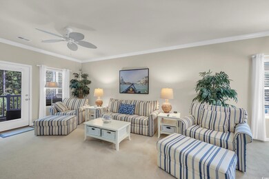 Living area featuring light colored carpet, crown molding, and ceiling fan