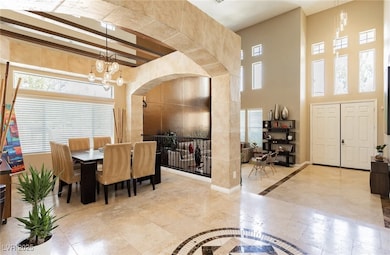 Dining space with an inviting chandelier, arched w