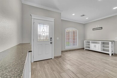 Foyer entrance with crown molding, light wood-type flooring, and recessed lighting