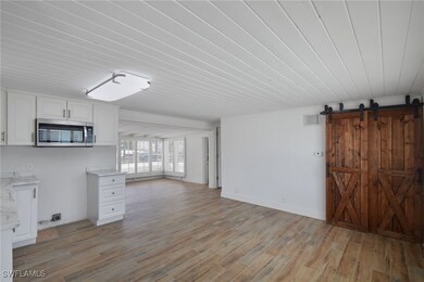 Unfurnished living room featuring a barn door, lig