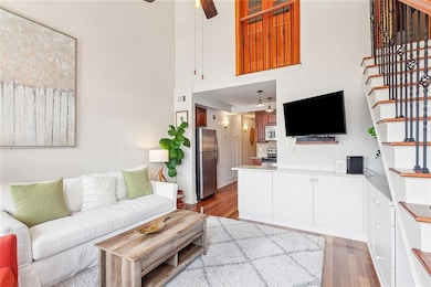 The unit is beautifully furnished and decorated. This looks back to the kitchen and also shows gorgeous built-ins as well as stairs leading to the primary bedroom and the closed doors upstairs, which can be easily opened.