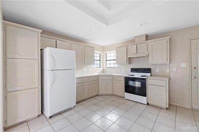 Kitchen with sink, light tile patterned floors, backsplash, electric range, and white refrigerator