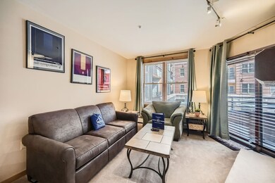 Carpeted living room featuring rail lighting and p