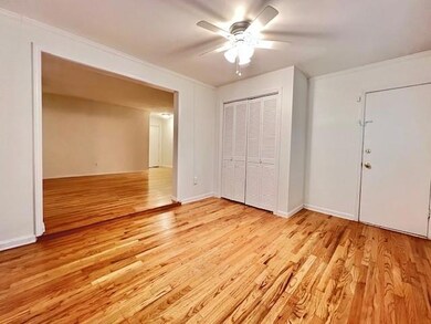 Unfurnished bedroom with light wood-style flooring, a closet, crown molding, and ceiling fan