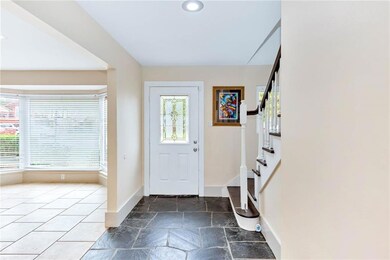 Front entrance and foyer with a coat closet and Living room with large windows that bring gorgeous natural LIGHT.