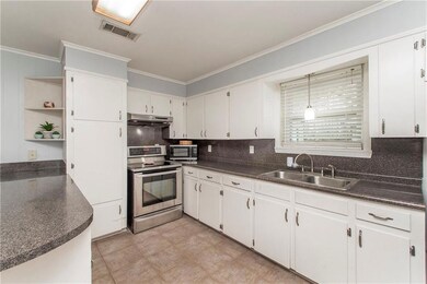 Kitchen w/ white wood cabinetry & SS appliances