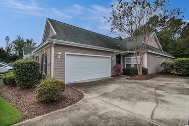 View of front facade featuring driveway, a shingled roof, an attached garage, and brick siding