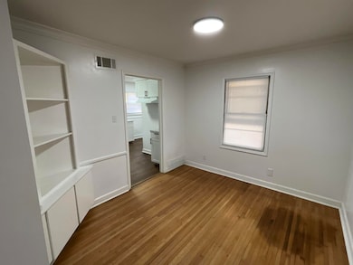 Unfurnished bedroom with wood-type flooring and cr