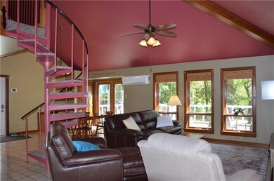 Wall of windows look out to the deck and woods