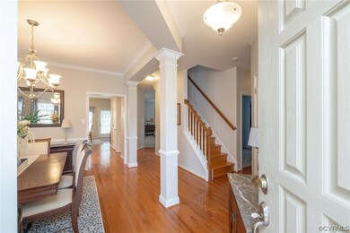 Wood floored entryway featuring crown molding