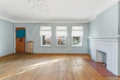 living room featuring hardwood / wood-style floors, radiator, and a brick fireplace