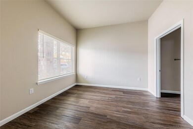 Empty room featuring baseboards and dark wood-sty