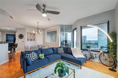 Living room featuring light wood-style floors, ceiling fan, and a chandelier