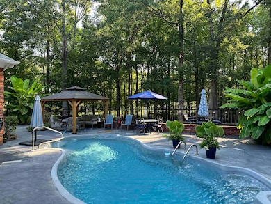 View of swimming pool with a gazebo, an outdoor ha