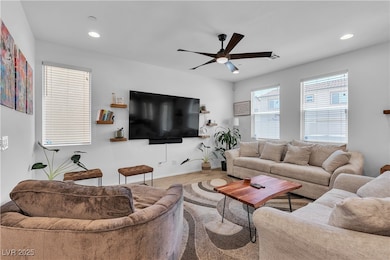 Living area featuring ceiling fan, wood finished f