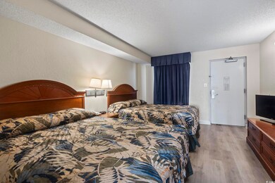 Bedroom with a textured ceiling and hardwood / woo
