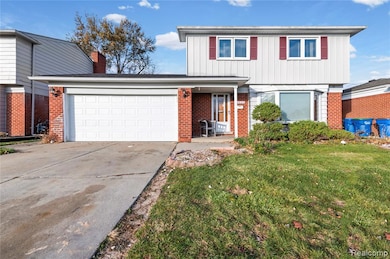 Traditional home featuring a front lawn, concrete driveway, brick siding, board and batten siding, and covered porch