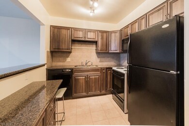 Updated kitchen with granite counter, tile backsplash, tile floor, refinished cabinets. All appliances stay.