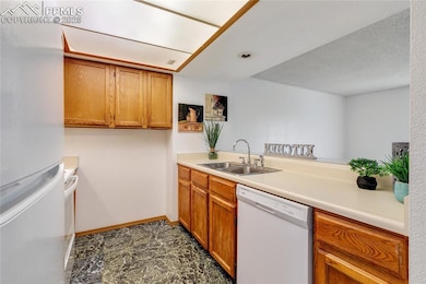 Kitchen with white appliances, sink, and a texture