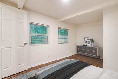 Bedroom with beam ceiling and dark wood-type floor