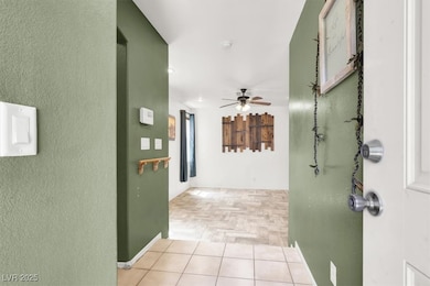 Hallway featuring a textured wall and baseboards