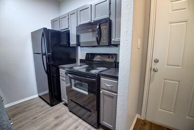 Kitchen with black appliances, dark countertops, 