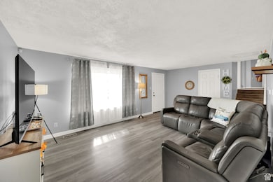 Living room featuring a textured ceiling and wood finished floors
