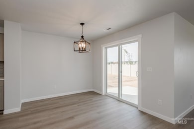 Unfurnished dining area featuring light wood finished floors and a chandelier