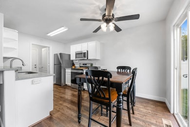 Dining space featuring dark wood-style flooring and ceiling fan