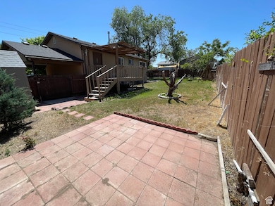 Fenced backyard featuring a deck, stairway, and a patio area