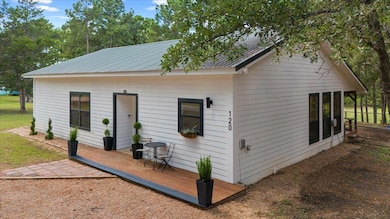 Back of property with a wooden deck and metal roof