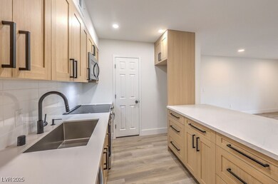 Kitchen featuring light wood-style flooring, a sin