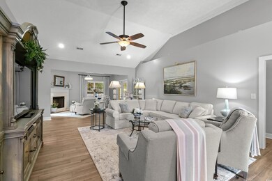Living room with ceiling fan, vaulted ceiling, and