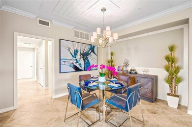 Tiled dining space with crown molding, visible vents, baseboards, and a notable chandelier