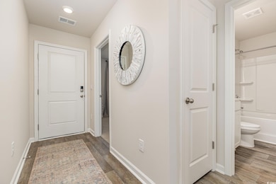 Doorway to outside featuring baseboards and wood finished floors