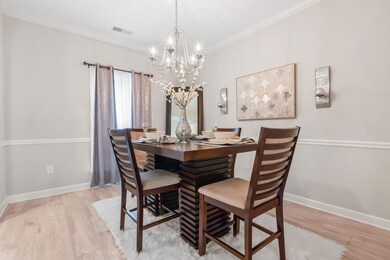 Dining room with crown molding, light hardwood / w