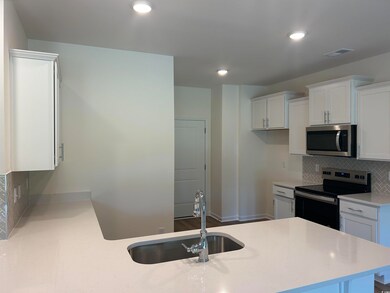Kitchen with white cabinetry, backsplash, kitchen 