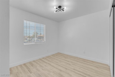 Unfurnished room with wood finished floors and bas
