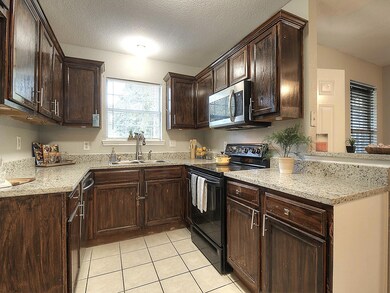 Kitchen featuring light tile patterned floors, lig