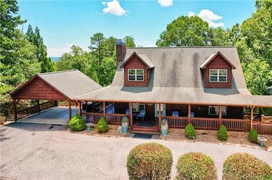 View of front of home with driveway, a shingled roof, a carport, a chimney, and covered porch