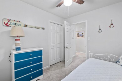 Carpeted bedroom featuring ceiling fan and a close