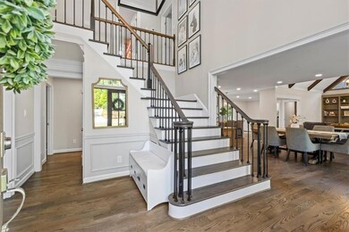 Stairway featuring wood finished floors and ornamental molding